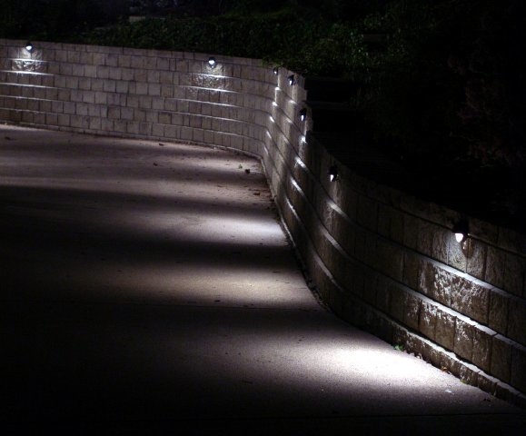 Puck-Lights used to illuminate a driveway retaining wall installed by The Illuminators Outdoor Lighting