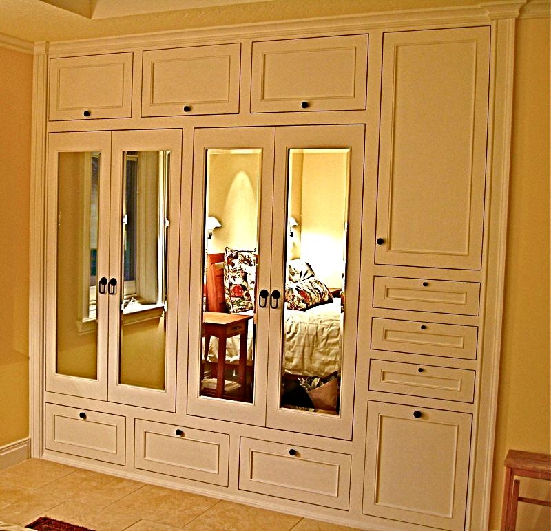 Hers, built in custom closet designed and handcrafted by Philip Snyder of PS Woodworking features columns, flush doors, beveled mirror doors, interior lighting, aromatic Cedar lining throughout, a laundry hamper and a shoe rack.
