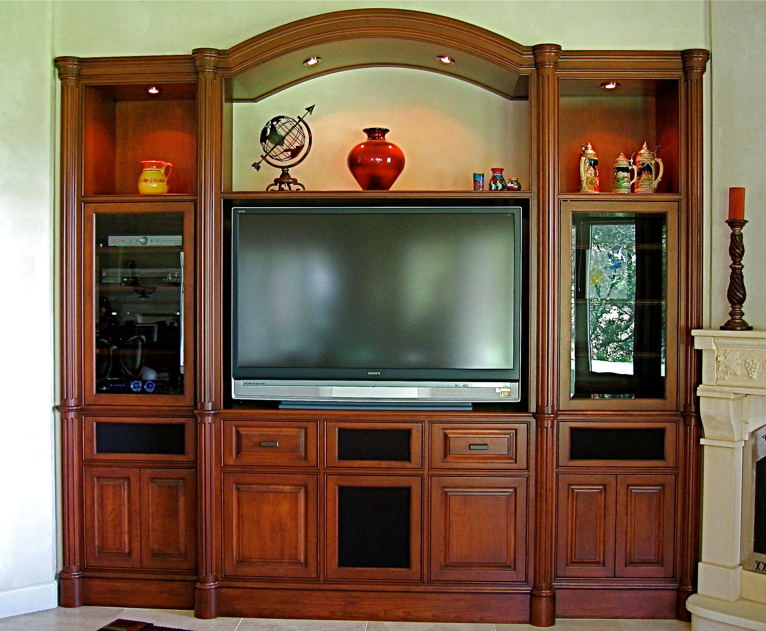 Custom Cherry built in media center designed and handcrafted by Philip Snyder of PS Woodworking features a graceful arch, round fluted columns, plinths and capitals, speakers behind cloth panels, custom one of a kind moldings and is the focal point of the great room.